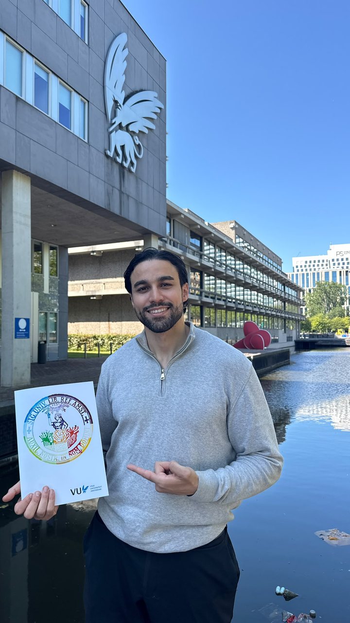 Yassine Kaddouri met zijn bul voor de Vrije Universiteit in Amsterdam.